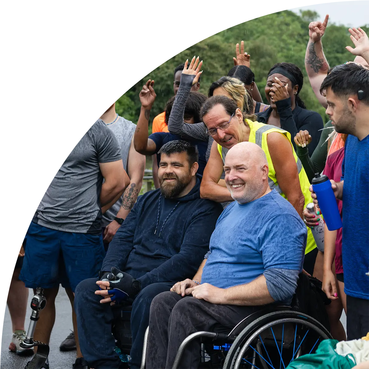 Diverse group outdoors smiling and celebrating after a community or fitness event, including people with disabilities.