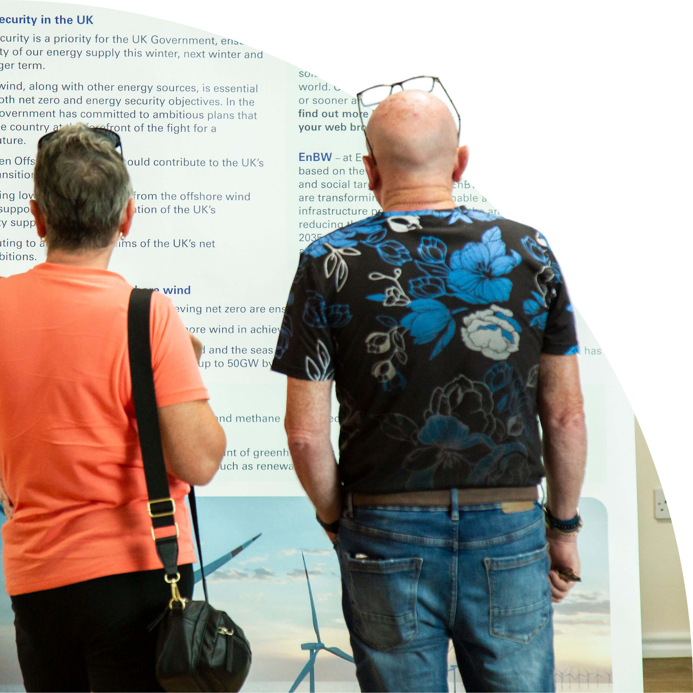 Two people reading an informational display about UK energy security and offshore wind